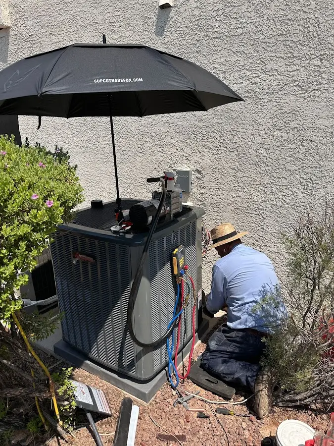 HVAC technician performing outdoor AC maintenance in Lawrence