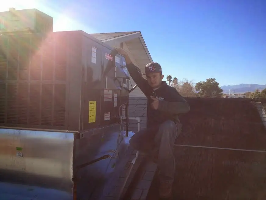 HVAC technician performing HVAC Inspection on a rooftop unit in Lawrence